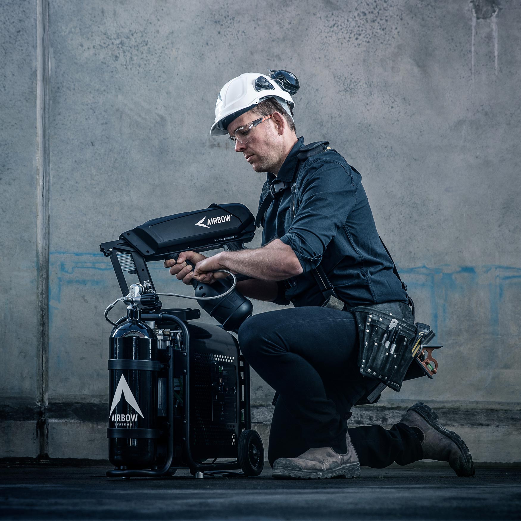 Photo of a builder filling the Airbow nail gun with air from the Airbow compressor